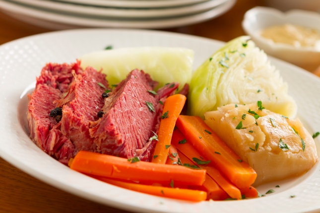 Corned beef, carrots, and onion on a white plate